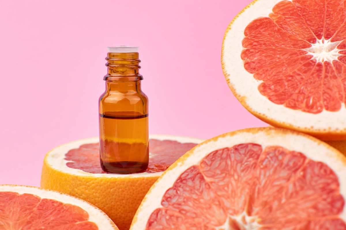 essential oil bottle placed on grapefruit